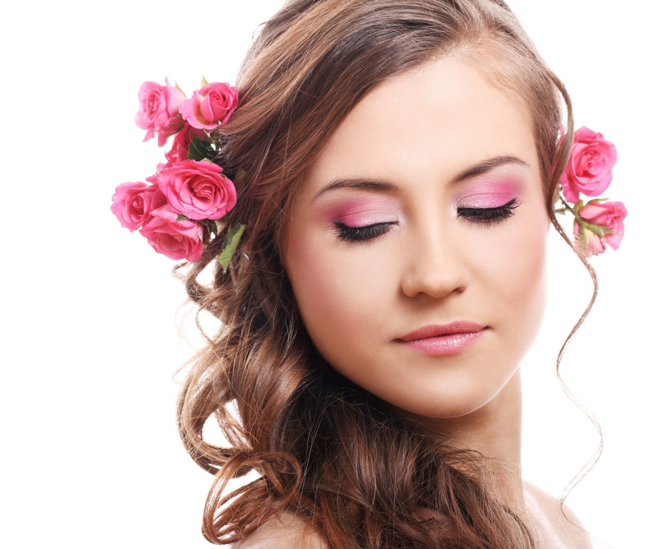 Beautiful woman with roses in hair over white background